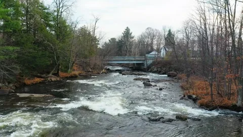 Crane shot with a drone, coming down over the river, near the small bridge .. Stock Footage 331833891