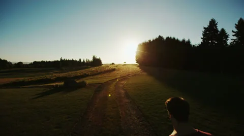Crane Shot of Man Walking Into Sunset on Farm Video stock 34372552