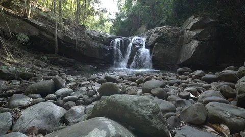 Crane shot of waterfall in rainforest with rocks in foreground Video stock 87193085
