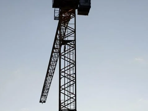 Crane silhouette ready, dramatic scene of tower crane prepared for lifting .. Stock Photos