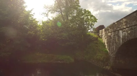 Crane up from stone bridge to reveal rolling countryside beyond Video stock 64636078