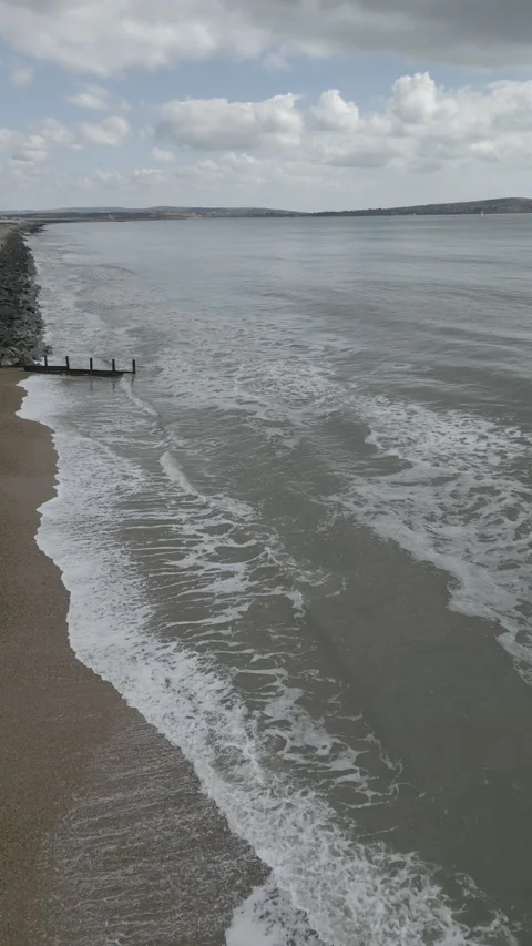 Crane-style Drone Shot of Waves Crashing on a Beach 스톡 동영상 238782150