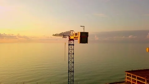 Crane at sunset from a bird's-eye view, sun's rays pass through crane structure. Stock Footage 161308308