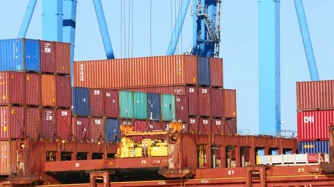 Crane taking a hatch cover off a container ship 4k intro video for business Stock Footage 101783243