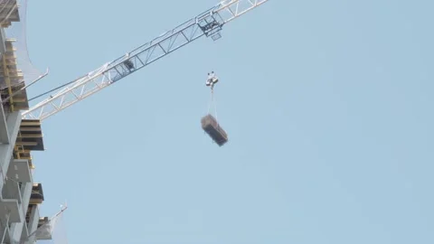 Crane transports building materials to construction site Stock Footage 132492325