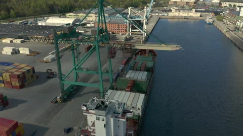 Crane unloading containers from cargo ship at industrial port Stock Footage 130595212