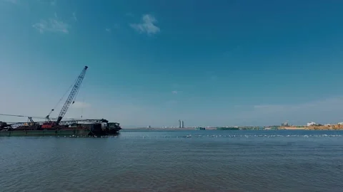 Crane Vessel Anchored in Sea with Distant City Skyline on Horizon Stock Footage 337028164