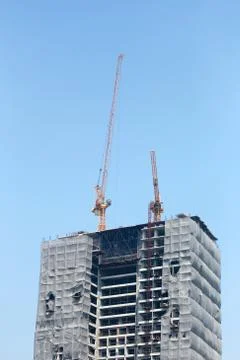 Crane working on a building under construction. Stock Photos