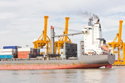 Crane working with container cargo in shipyard Stock Photos