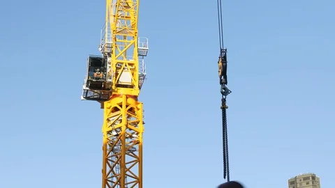 A crane works on construction in the sun 스톡 동영상 82707058