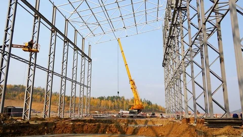 The crane works with loads on the construction site under the metal structures Stock Footage 74005006