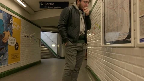 Crane: Young man studies intricate subway transit map in Paris France Stock Footage 147649996