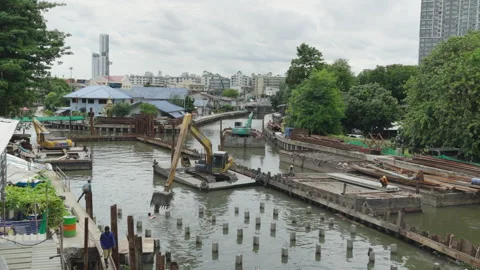Cranes and boats at a riverside construction site in Bangkok Stock Footage 345865286