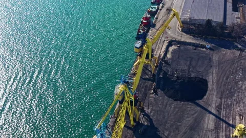 Cranes and cargo operation at a busy dock near the water during daylight with Stock Footage 331063978