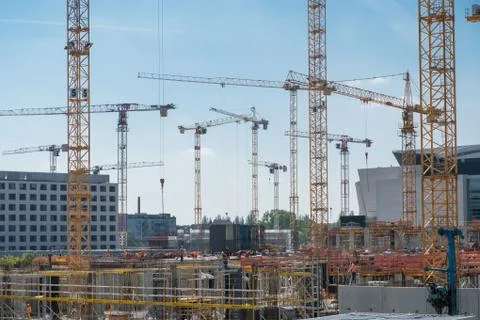 Cranes and construction workers onconstruction site Stock Photos