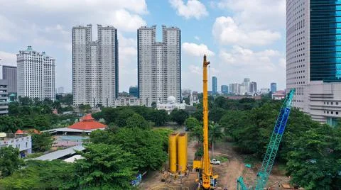 Cranes are in operation to work on the construction of a skyscraper in Jakarta Stock Photos
