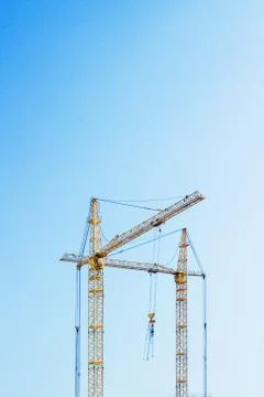Cranes on blue sky. Vertical composition Stock Photos