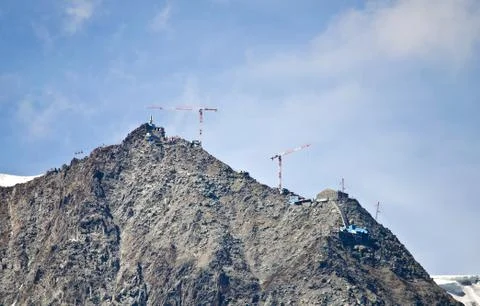Cranes building on top of mountain Fotos de archivo