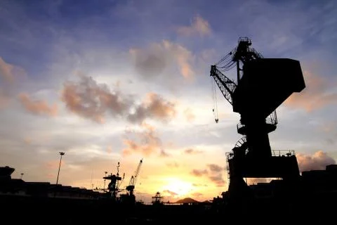 Cranes in dockside at sunset Stock Photos