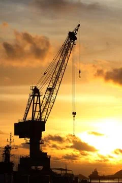 Cranes in dockside at sunset Stock Photos
