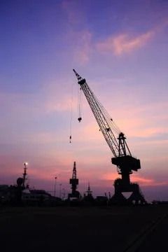 Cranes in dockside at sunset Stock Photos