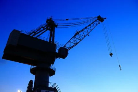 Cranes in dockyard  at sunset Stock Photos
