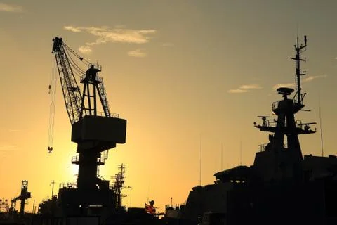 Cranes in dockyard  at sunset Stock Photos