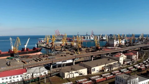Cranes elevators and a ship in a seaport on a sunny day Видео 105673391