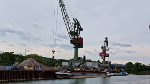 Cranes loading bulk material into barges at industrial port in Regensburg Stock Footage 310537599