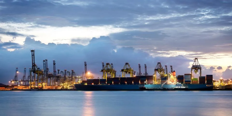 Cranes loading containers at a ship yard. Stock Photos