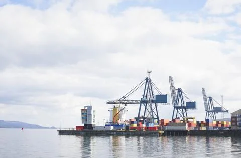 Cranes at logistics port terminal for offloading containers Stock Photos