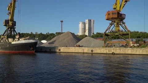 Cranes of the river port for loading barges carrying sand and gravel Stock Footage 158185887