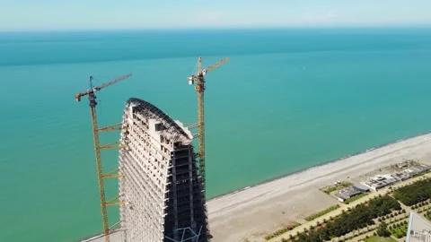 Cranes on the seaside skyscraper construction Stock Footage 168614199
