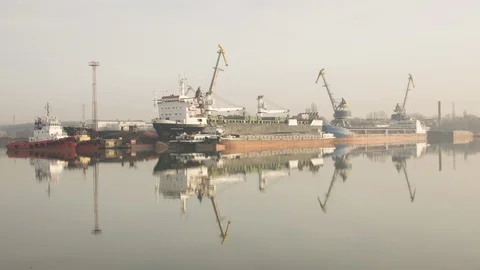 Cranes at the shipyard are reflected in the water. Stock Footage 86786535