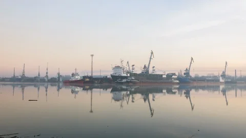Cranes at the shipyard are reflected in the water. Stock Footage 86786557