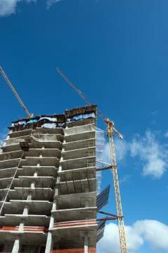 Cranes at a skyscraper construction. Stock Photos