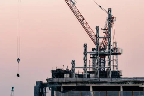 Cranes on top of under construction high-rise building Stock Photos