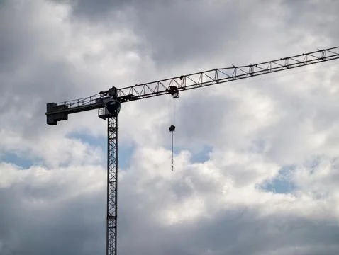 Cranes Under Clouds. Cinematic Scene Showcasing Tower Crane In Dramatic Ind.. Stock Photos