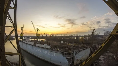 The cranes work in the dock. The day passes into night. Video stock 86787565
