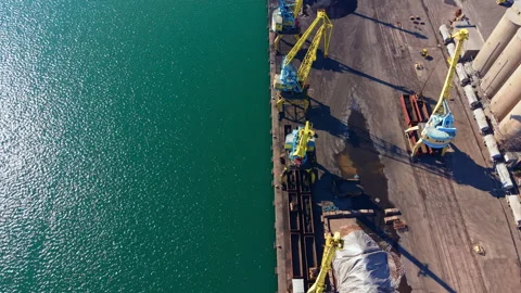 Cranes work at a loading dock by the sea in a busy port during the day under Stock Footage 336608016