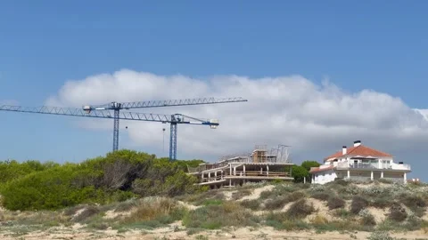 Cranes working against the blue sky. Construction of apartments on the seashore Stock Footage 284664244
