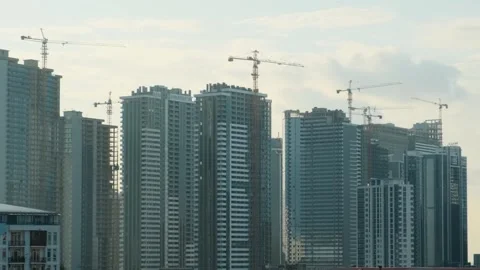 Cranes working on construction site of building modern city district with Stock Footage 265892187