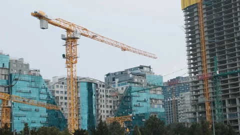 Cranes working on construction site of building modern city district with Stock Footage 269054948