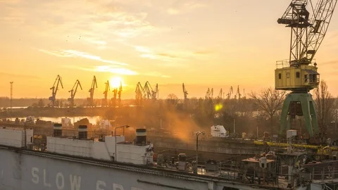Cranes working in the dock, at the shipyard. Day turns night. Video stock 86788227