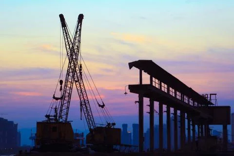 Cranes working at sunset Stock Photos
