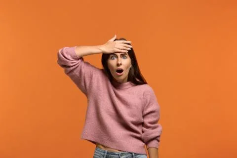 Crap, I forgot to do this. Portrait of worried stunned woman in pink sweater  Stock Photos
