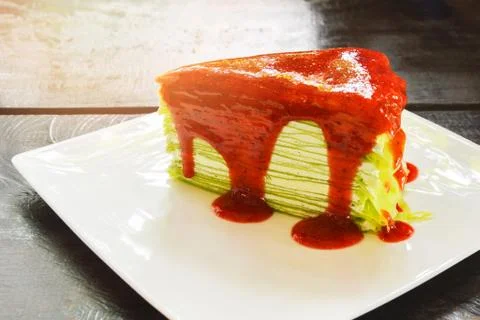 Crape cake / green tea crape cake with Strawberry sauce on white plate rustic Stock Photos