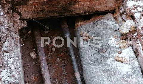 Crash, burst pipes and leaking water under the earth. Excavated pipes in the Stock Photos