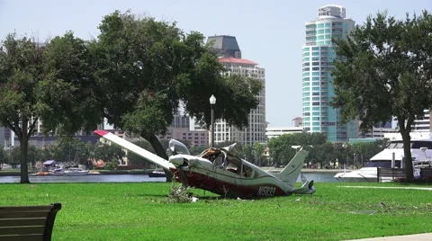 Crash Wreckage Of A Small Plane On Grass Field City Skyline In Background 4K. Video stock 41769871