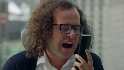 CRASH ZOOM Crazy nerdy looking manager screaming into the phone during the call Stock Footage 205612284